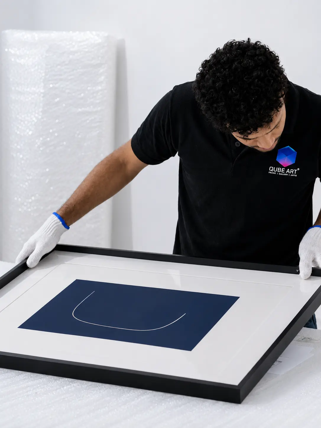 Qube Art fitting and finishing a custom framed artwork