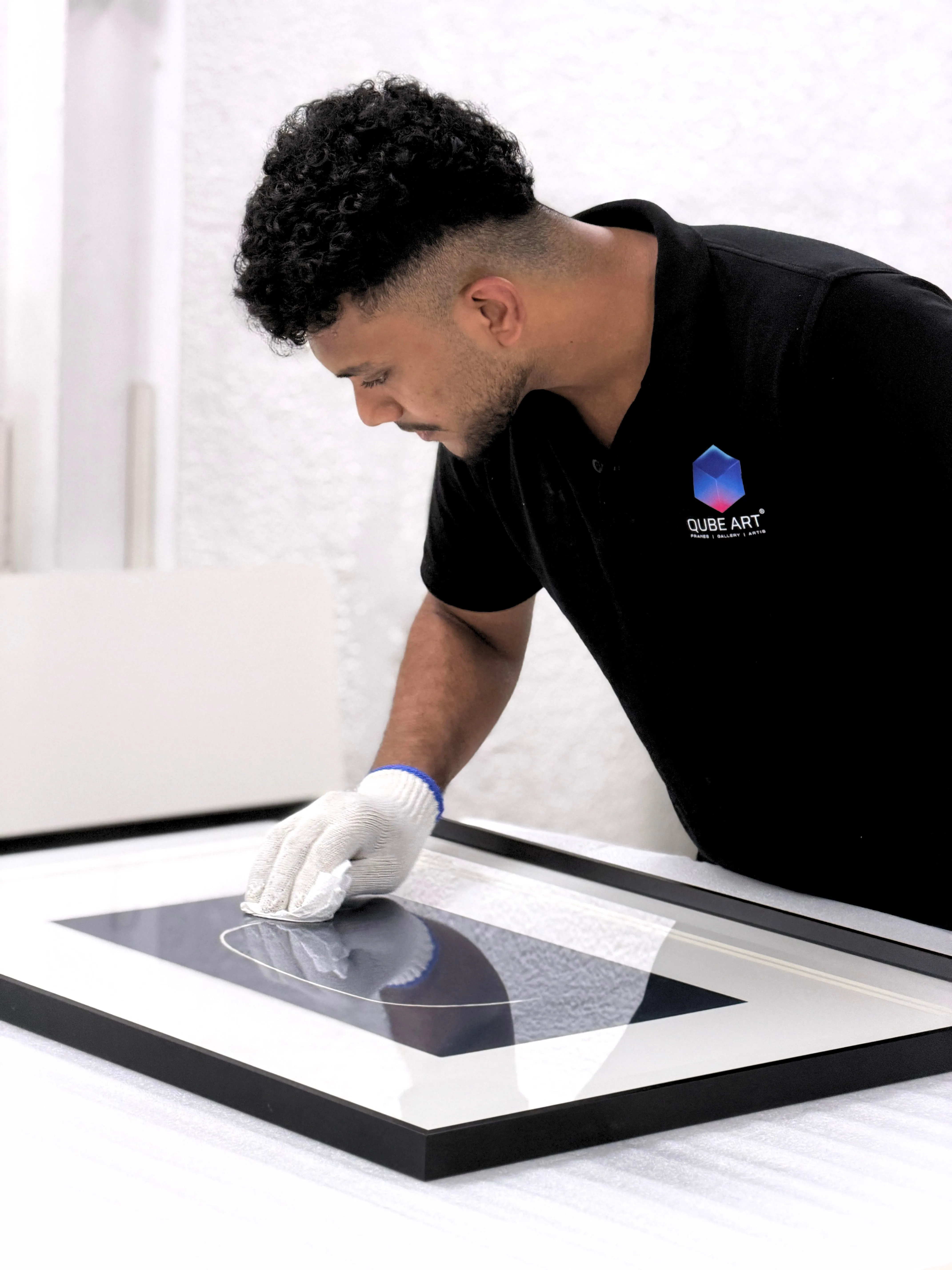 Qube Art craftsman fitting and finishing a custom frame